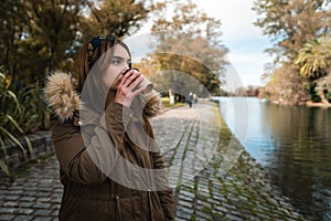 Caucasian woman drinking coffee during a walk at park