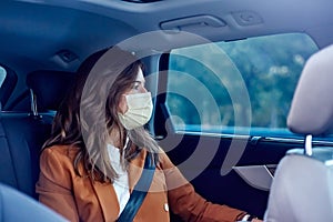 Caucasian woman with a face mask traveling in a car - Woman on business trip