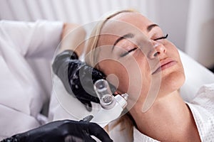 Caucasian woman getting face peeling procedure in a beauty clinic