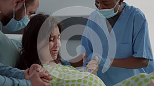 Caucasian woman giving birth to child in hospital ward