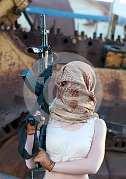 Caucasian woman with a gun in the Arab scarf