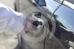 Caucasian woman hand opening car using key