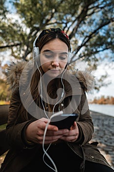 Caucasian woman with headphones at park