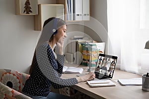 Caucasian woman in headphones talk on video call with colleagues