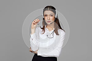 caucasian woman with headset on gray background
