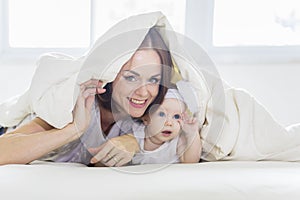 Caucasian woman and her baby under a blanket
