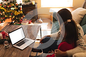 Caucasian woman and her daughter spending time at home together at christmas