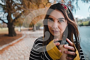 Caucasian woman holding coffee at park