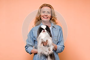 Caucasian woman holding and comforting cute pet dogs japanese chin