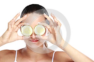 Caucasian woman holding slices of cucumber for make up mask