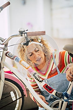 Caucasian woman at home create a boho coloured happy bike with recycled pieces - artist at work and people love job and leisure