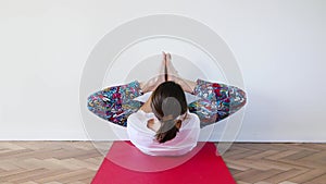 Caucasian woman in inverted butterfly yoga posture with strech spine in indoor