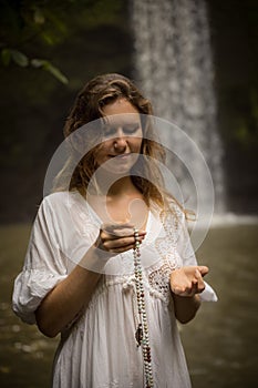 Caucasian woman keeping count during pray and meditation. Buddhist japa mala. Strands of gemstones beads. Hand in gyan mudra.