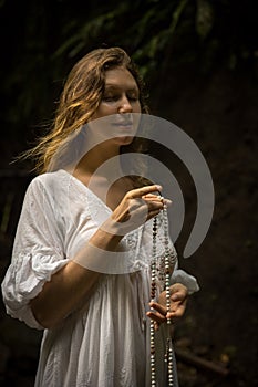 Caucasian woman keeping count during pray and meditation. Buddhist japa mala. Strands of gemstones beads. Religion concept.