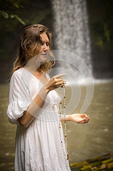 Caucasian woman keeping count during pray and meditation. Buddhist japa mala. Strands of gemstones beads. Religion concept.