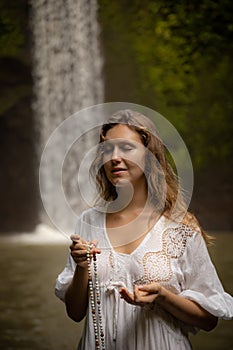 Caucasian woman keeping count during pray and meditation. Buddhist japa mala. Strands of gemstones beads. Religion concept.