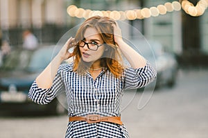 Caucasian woman and light bulb with bokeh background. street style fashion. European trip, old city, summer vacation. happy