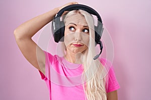 Caucasian woman listening to music using headphones confuse and wonder about question