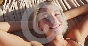 Caucasian woman lying on a hammock on the beach