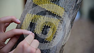 Caucasian woman makes handmade board with nails