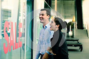 Caucasian woman and man excited when see the price tag on sale at the store