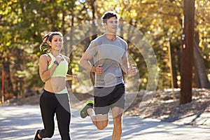 Caucasian woman and man jogging on a country road, close up