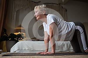 Caucasian woman on mat doing cat stretch posture for spine