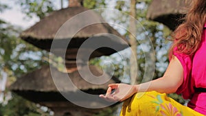 caucasian woman meditating yoga in balinese temple