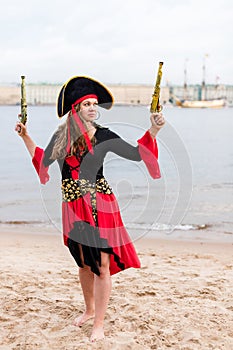 Caucasian woman in pirate costume raised to the top two toy guns