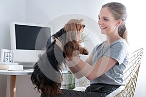 Caucasian woman playing with her dog at home.