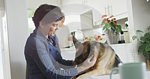 Caucasian woman playing her dog in the living room at home