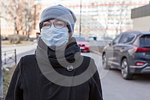 Caucasian woman portrait standing on street wearing medical mask and glasses