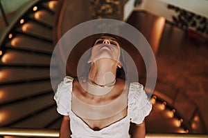 Caucasian woman posing at staircase of a hotel