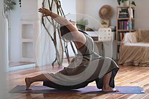 Caucasian woman practicing yoga doing warrior pose variation