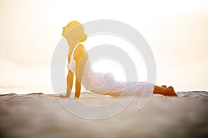 Caucasian woman practicing yoga at seashore