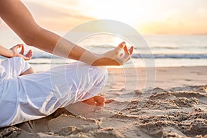 Caucasian woman practicing yoga at seashore