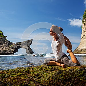 Caucasian woman practicing yoga at seashore