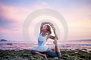 Caucasian woman practicing yoga at seashore