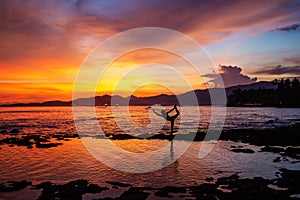 Caucasian woman practicing yoga at seashore