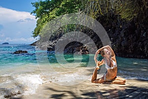 Caucasian woman practicing yoga at seashore