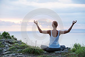 Caucasian woman practicing yoga at seashore