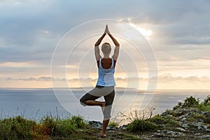 Caucasian woman practicing yoga at seashore