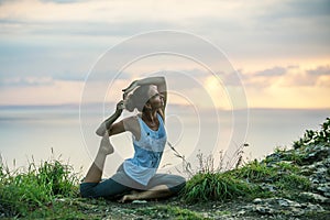 Caucasian woman practicing yoga at seashore