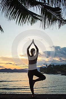 Caucasian woman practicing yoga at seashore