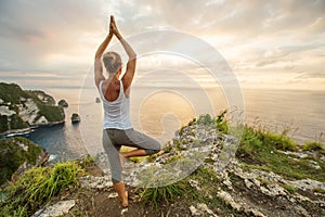 Caucasian woman practicing yoga at seashore