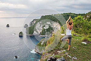 Caucasian woman practicing yoga at seashore