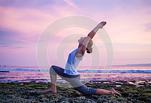 Caucasian woman practicing yoga at seashore