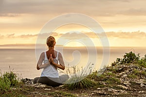 Caucasian woman practicing yoga at seashore