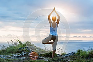 Caucasian woman practicing yoga at seashore