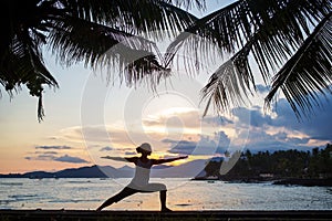 Caucasian woman practicing yoga at seashore